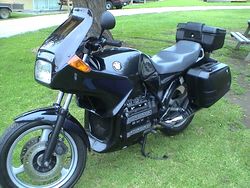 Black BMW K75S with topbox and panniers, parked on grass